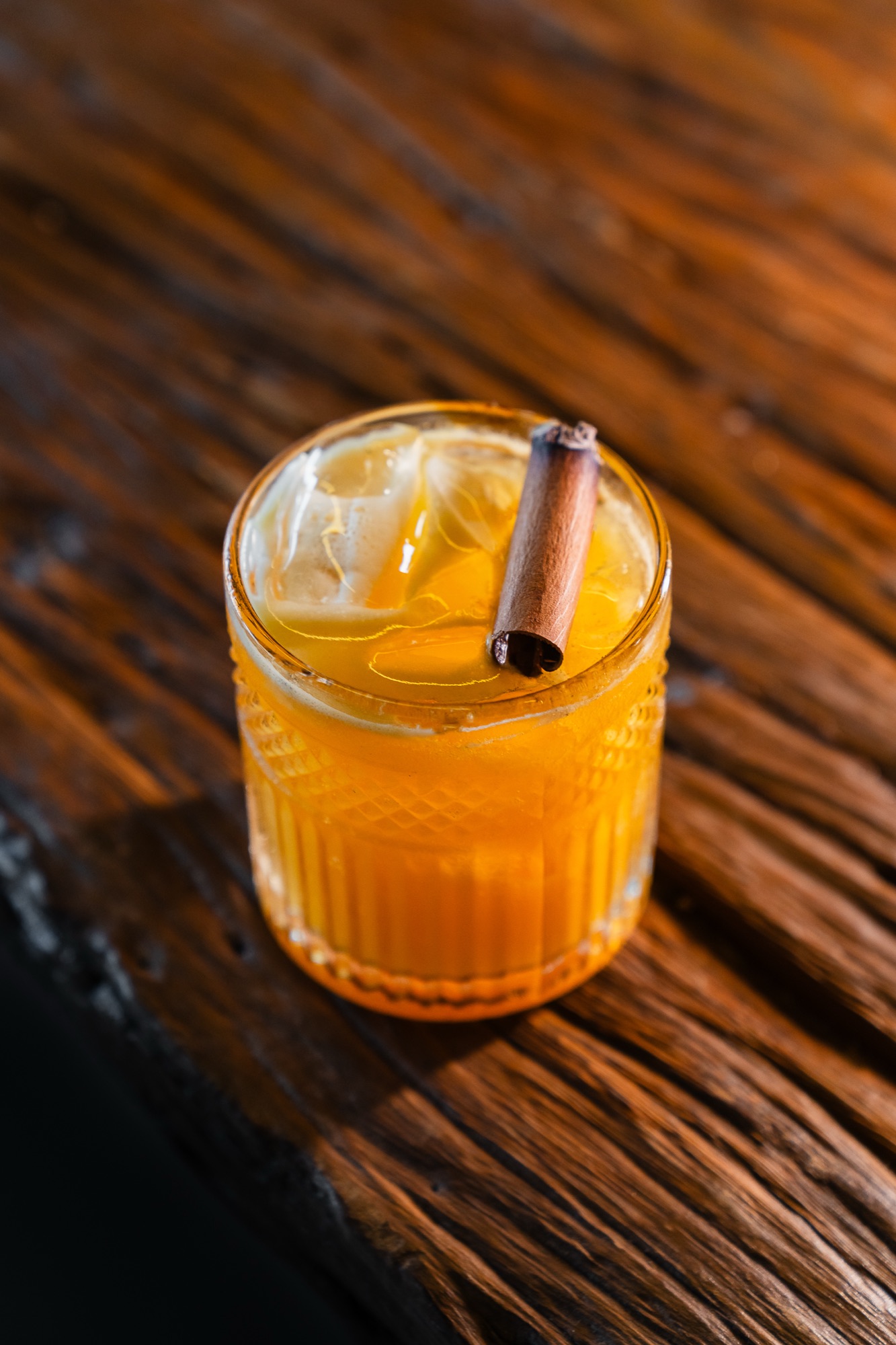 Drink servido em copo de vidro sobre madeira